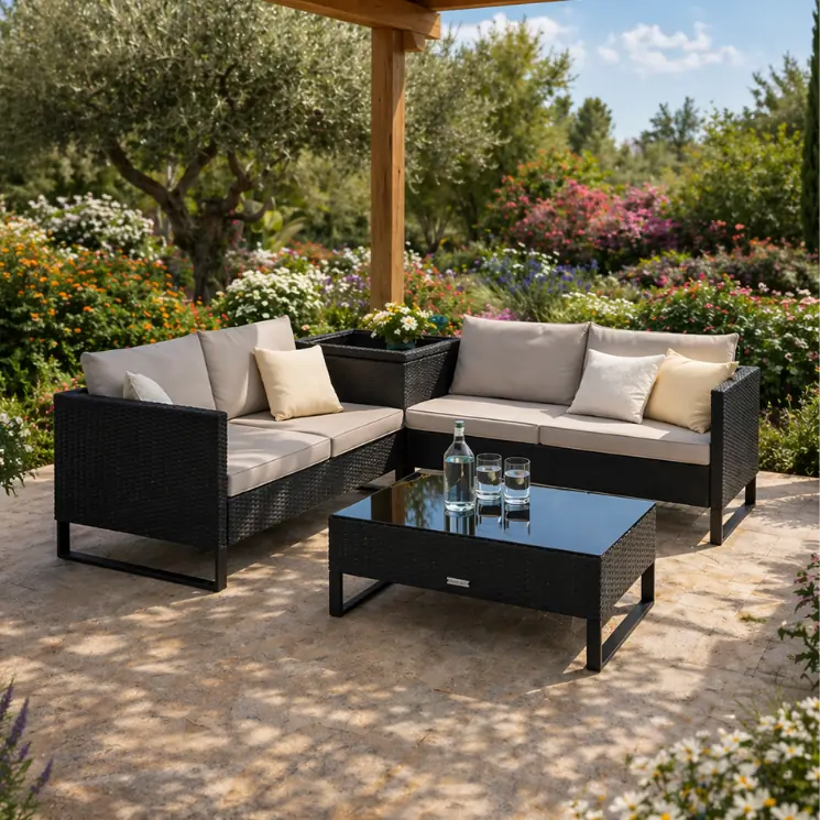 Divano ad angolo in vimini nero con cuscini chiari e tavolino abbinato.